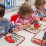 Niños en aula jugando con plastilina de colores